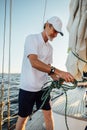 Mature yachtsman adjusting the rope