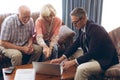 Matured male physician and senior couple discussing over laptop at retirement home Royalty Free Stock Photo