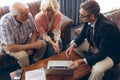 Matured male physician and senior couple discussing over laptop at retirement home Royalty Free Stock Photo