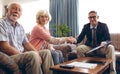 Matured male physician shaking hand and smiling at retirement home Royalty Free Stock Photo