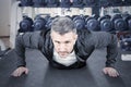 Matured man doing push-ups in weight room Royalty Free Stock Photo