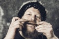 Matured man in fur hat playing jews harp Royalty Free Stock Photo