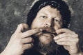 Matured man in fur hat playing jews harp Royalty Free Stock Photo