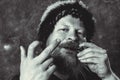 Matured man in fur hat playing jews harp