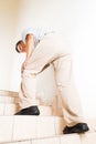 Matured man suffering acute knee joint pain climbing stairs Royalty Free Stock Photo