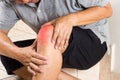 Matured man suffering painful knee joint seated on steps Royalty Free Stock Photo