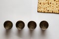 Matzah - Jewish bread for Passover. Next to four silver cups.