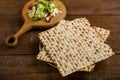 Matzah on a plate and maror on a wooden board for a Pesach Seder.