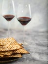 Matzah and red wine in two glasses on a beautiful smoky often gray background. Jewish Passover, Judaism, religion, Torah,