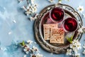 Matzah and spring flowers on light blue background. Jewish holiday bread matza or matzoh