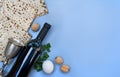 Matzo, wine, silver bowl, white egg and walnuts for passover celebration on blue background with space for text. Royalty Free Stock Photo