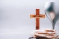 Matzos unleavened bread, chalice of wine, wooden cross on grey background. Christian communion for reminder of Jesus sacrifice.