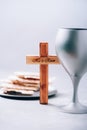 Matzos unleavened bread, chalice of wine, wooden cross on grey background. Christian communion for reminder of Jesus sacrifice.