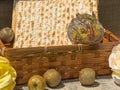 Matzot in a wicker basket with souvenir apples and roses on black background.