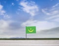 Mauritania flag with vast meadow and blue sky behind it.