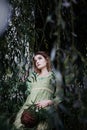 Mavka. A beautiful woman in a green dress is walking through the forest. Royalty Free Stock Photo