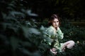 Mavka. A beautiful woman in a green dress is walking through the forest. Royalty Free Stock Photo