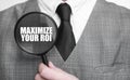 MAXIMIZE YOUR ROI on magnifying glass and businessman