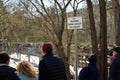 Maximum bridge capacity sign with crowd of people on a wooden bridge