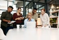 Maximum effort gets maximum results. a group of businesspeople using a laptop during a meeting in a modern office.