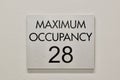 Maximum Occupancy sign on a white interior wall in a commercial building.
