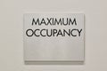 Maximum Occupancy sign on a white interior wall in a commercial building.