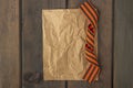 9 May background - George ribbon and note paper on the wooden background. Victory day or fatherland defender day concept. Top view