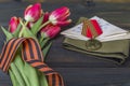 9 May background - George ribbon, red flowers front-line letters, military cap and orders on the wooden background. Victory day or