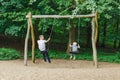 Father And Son Having Fun On Swing In Playground in park Royalty Free Stock Photo