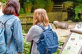 Woman tourist reading information board sign with short info about animal species in the Berlin Zoo