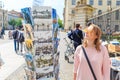 young girl chooses a postcard as souvenir outdoors