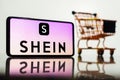 May 8, 2023, Brazil. In this photo illustration, the Shein logo seen displayed on a smartphone along with a shopping cart