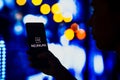 May 2, 2022, Brazil. In this photo illustration, a silhouetted woman holds a smartphone with the Neuralink logo displayed on the