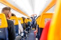 Passengers seating and listening to the crew members steward safety instructions inside the Ryanair