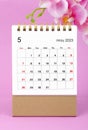 The May 2023 calendar desk and pink orchid on pink background