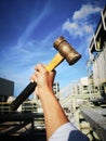 May day, Hand hold brass hammer with blue sky ba ground.