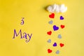 3 may day of month, colorful hearts rain from a white cotton cloud on a yellow background. Valentine's day, love and