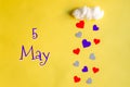 5 may day of month, colorful hearts rain from a white cotton cloud on a yellow background. Valentine's day, love and