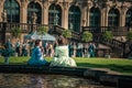 17 May 2019 Dresden, Germany - Two women in barocco style dresses with fancy umbrellas sitting near Zwinger fountain during costum