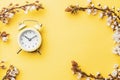 May flowers. Spring blossom and April floral nature with alarm clock on yellow background. Beautiful scene with blooming Royalty Free Stock Photo