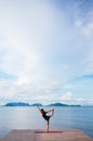 Asian woman doing yoga on the wooden pier by the sea. Koh lanta, Krabi, Thailand Royalty Free Stock Photo