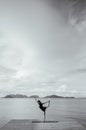 Asian woman doing yoga on the wooden pier by the sea. Koh lanta, Krabi, Thailand