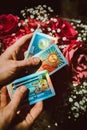 May, 2022 - Kyiv, Ukraine. Fortune teller holding oracle cards in hand on flowers background. Tarot reader. Future Royalty Free Stock Photo