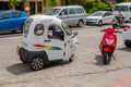 A covered three-wheeled electric motor scooter.