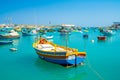 Beautiful view on the traditional eyed colorful boats Luzzu in the Harbor of Mediterranean fishing village Marsaxlokk, Malta Royalty Free Stock Photo