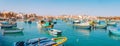 Beautiful view on the traditional eyed colorful boats Luzzu in the Harbor of Mediterranean fishing village Marsaxlokk, Malta Royalty Free Stock Photo