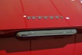 May 2022 Modena, Italy: Ferrari logo icon close-up on red car. details of the sportscar