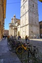 May 2022 Modena, Italy: Tower Ghirlandina and the Duomo Modena, bicycles parked, people walking on the square piazza della Torre o