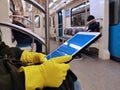 May 2020, Moscow, Metro. Hands in yellow gloves hold the iPad. Precautions against coronavirus infection in the Moscow metro.