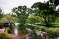 Clear natural stream with cottage and vintage old water turbine, beautiful garden of Daio Wasabi Farm - Hotaka - Nagano, Japan Royalty Free Stock Photo